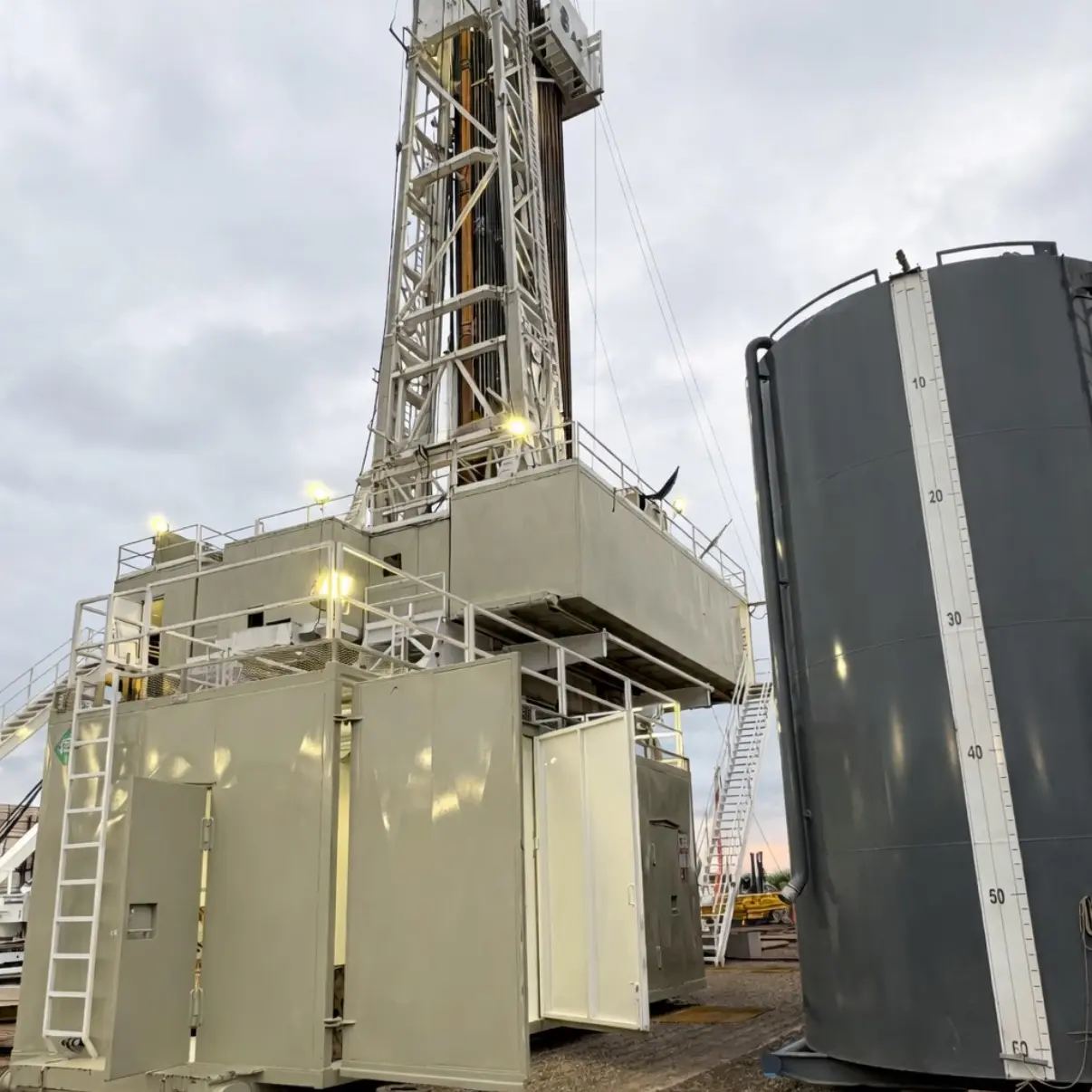 Industrial drilling rig with welded steel framework, platforms, and storage tank